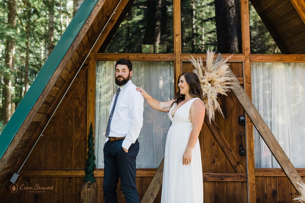 A couple shares a first look on the porch of an a-frame cabin near Mt. Rainier National Park. 