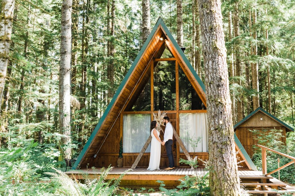 A couple holds hands while celebrating an intimate wedding at a a-frame airbnb. 