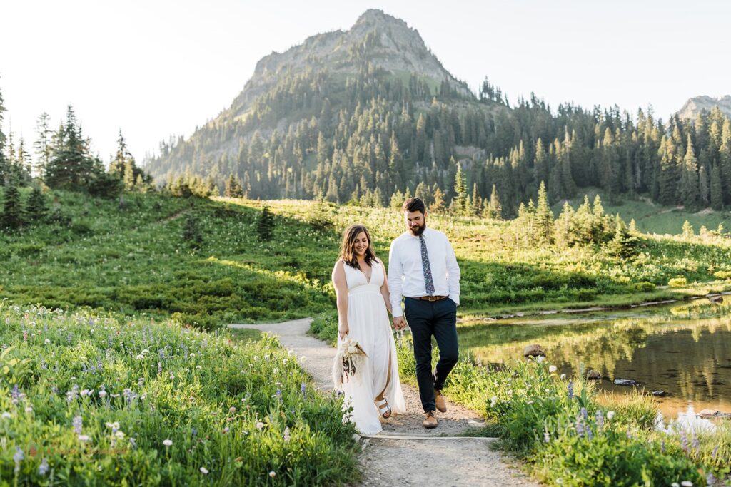 A couple walks along an easy Mt. Rainier hiking trail around Tipsoo Lake during their outdoor elopement. 