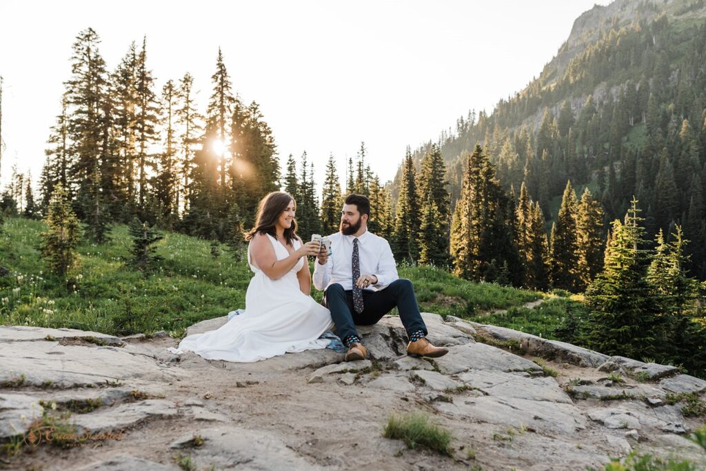 A couple toasts beers at Sunset during their Tipsoo Lake elopement in Mt. Rainier National Park. 