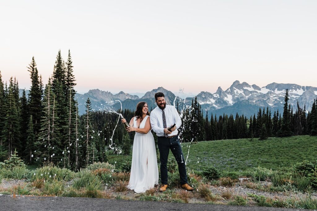 A Mt. Rainier elopement couple pop champagne with the Cascades in the background. 
