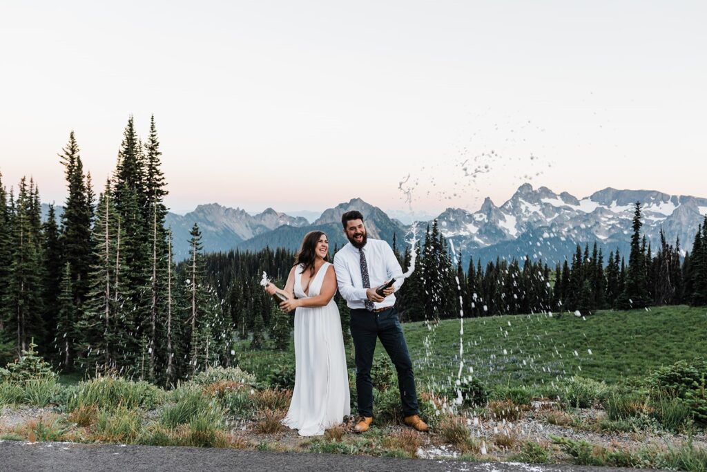 A Washington elopement couple pop champagne at Sunset over the Cascade Range. 