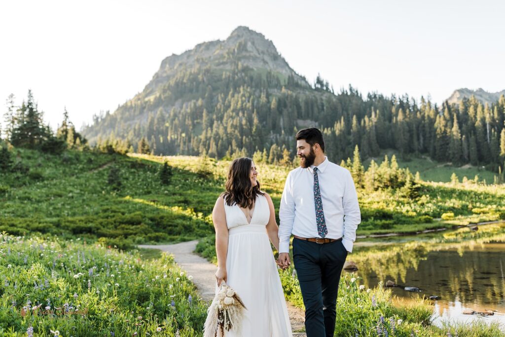 A couple holds hands during their Tipsoo Lake elopement at Sunset. 