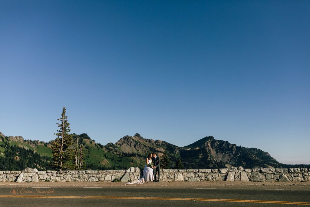 A couple sits along an overlook in Mt. Rainier National Park during their Washington elopement. 