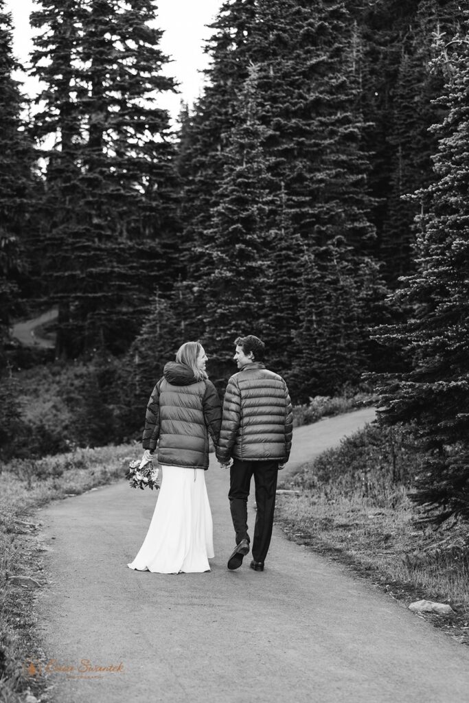 A couple smiles at one another while walking and holding hands along Mount Fremont Lookout Trail in Mt. Rainier National Park. 