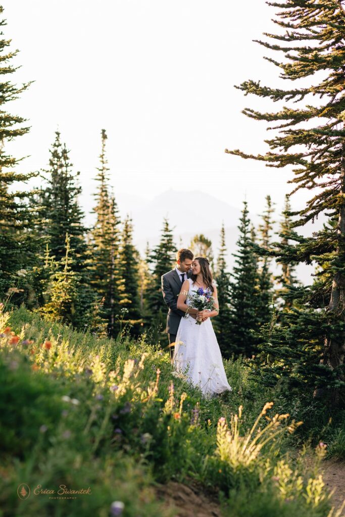 A couple elopes in a wildflower meadow in Mt. Rainier National Park. 