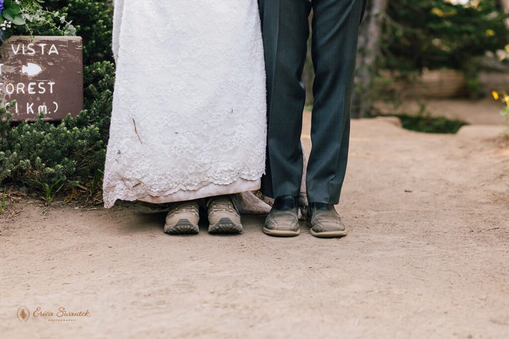 A Mt. Rainier hiking elopement couple shows off their hiking boots with wedding attire. 