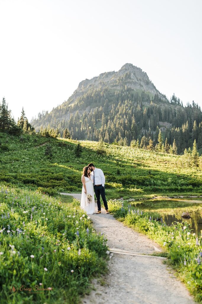 A couple embraces along a path during their lakeside elopement at Tipsoo Lake in Mt. Rainier National Park. 