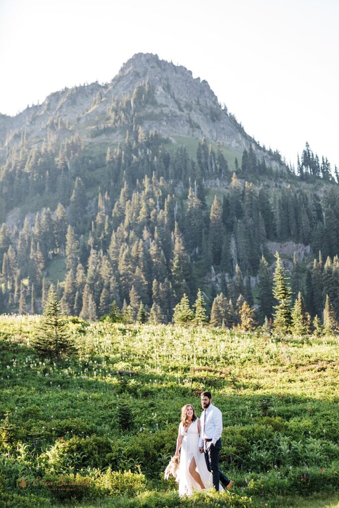 A Washington elopement couple walks along a trail to one of many lakeside Mt. Rainier wedding locations.