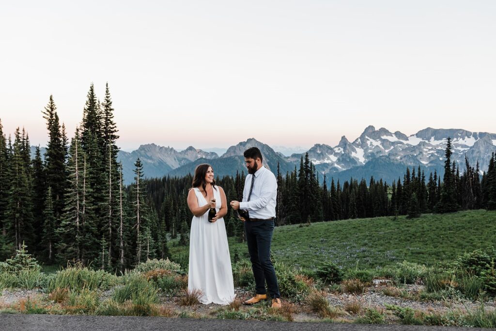 A couple celebrates a Summer Mt. Rainier elopement by popping champagne. 