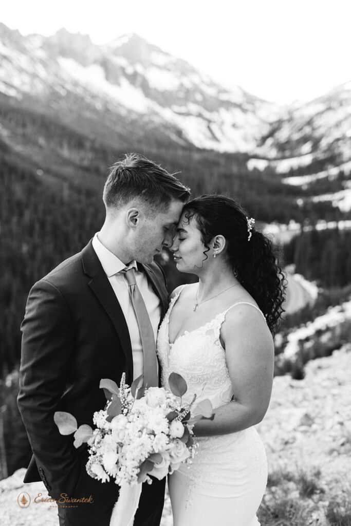 A couple embraces one another on a cliff's edge during their North Cascades elopement at Washington Pass.