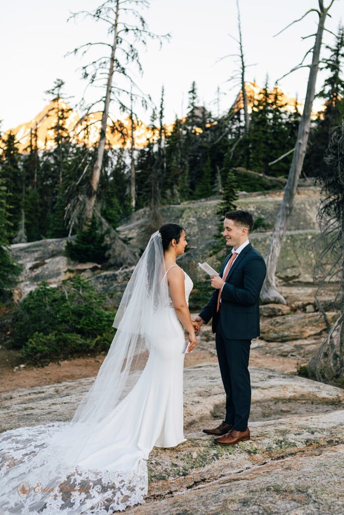 A North Cascades elopement couple read vows to one another during an outdoor ceremony. 