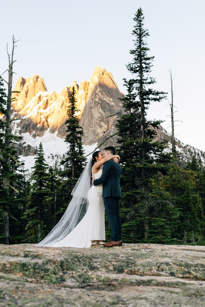 A North Cascades elopement couple kisses during their outdoor vow ceremony. 