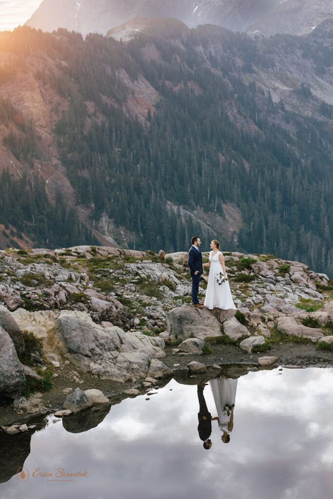 A Washington elopement couple in formal wedding attire stands near a pond during their Artist Point ceremony. 