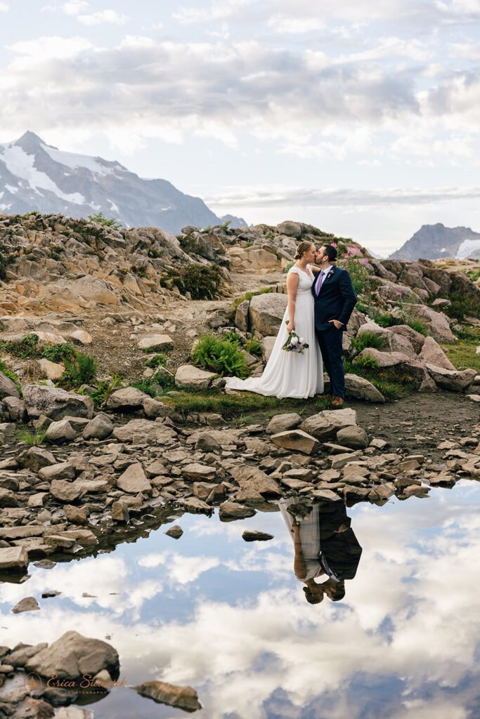 An Artist Point elopement couple kisses along Artist Ridge Trail with mountains in the background. 