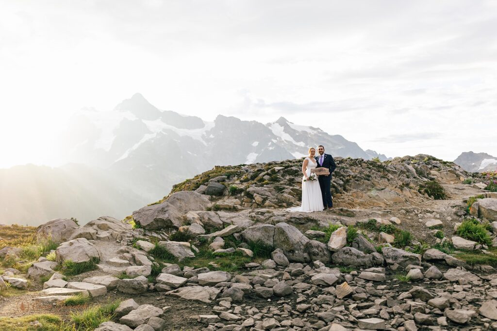 A couple holds an elopement sign to celebrate their North Cascades elopement.