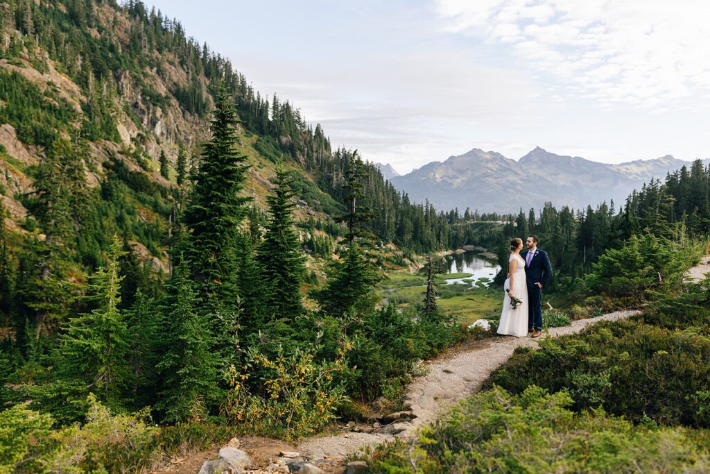 A couple in wedding attire embraces and admires one another near Reflection Lakes during their North Cascades elopement. 