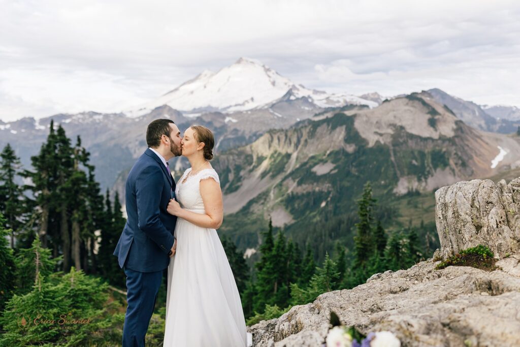 A Artist Point elopement couple kisses during their vow ceremony with Mt. Baker in the background. 