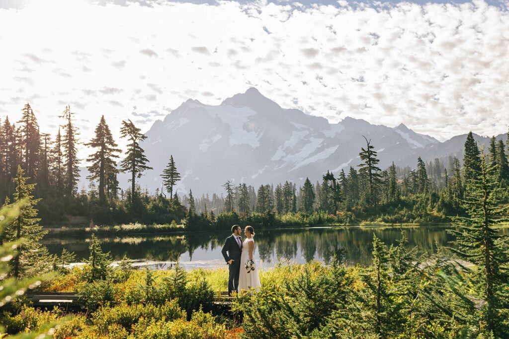 a dreamy elopement couple at an alpine lake with  mountain views in the backdrop 