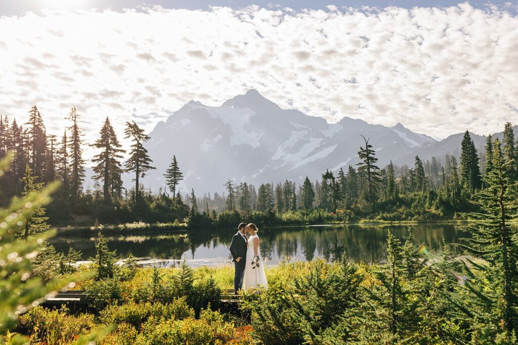 A North Cascades elopement couple stands in front of Bagley Lakes at Sunrise. 