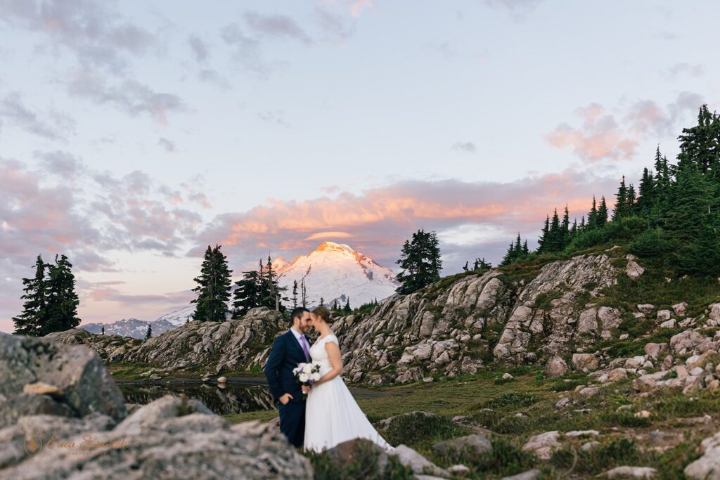 A North Cascades elopement couple holds in another close during Sunrise with Mt. Baker in the distance. 
