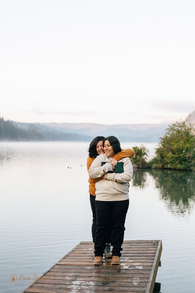 An Oregon elopement couple embraces on a dock overlooking a lake near Sisters, Oregon. 