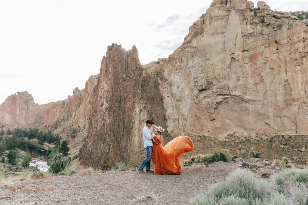 A bride in a boho orange dress embraces her groom in Rock Smith State Park. 