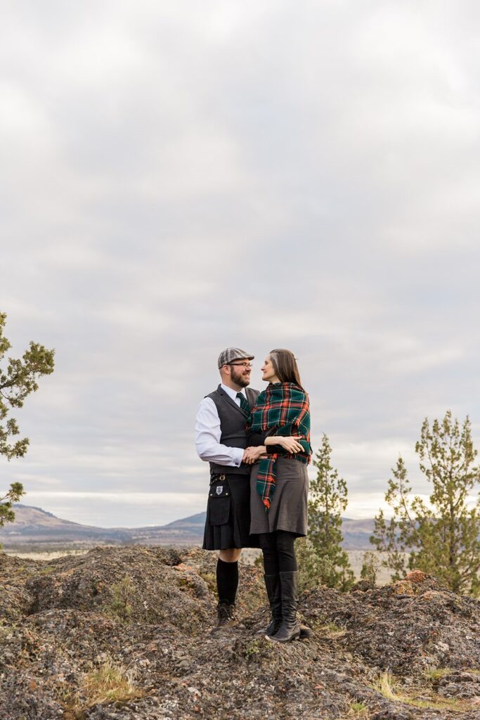 An intimate elopement couple embrace on an overlook at Crooked River Grasslands. 