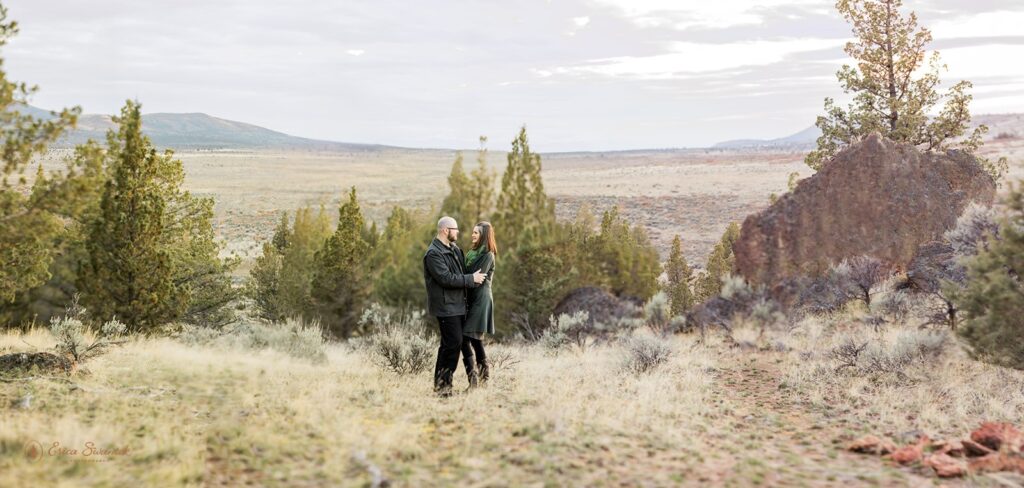 An Oregon elopement couple embrace in an open space at Crooked River Grasslands near Bend, Oregon. 