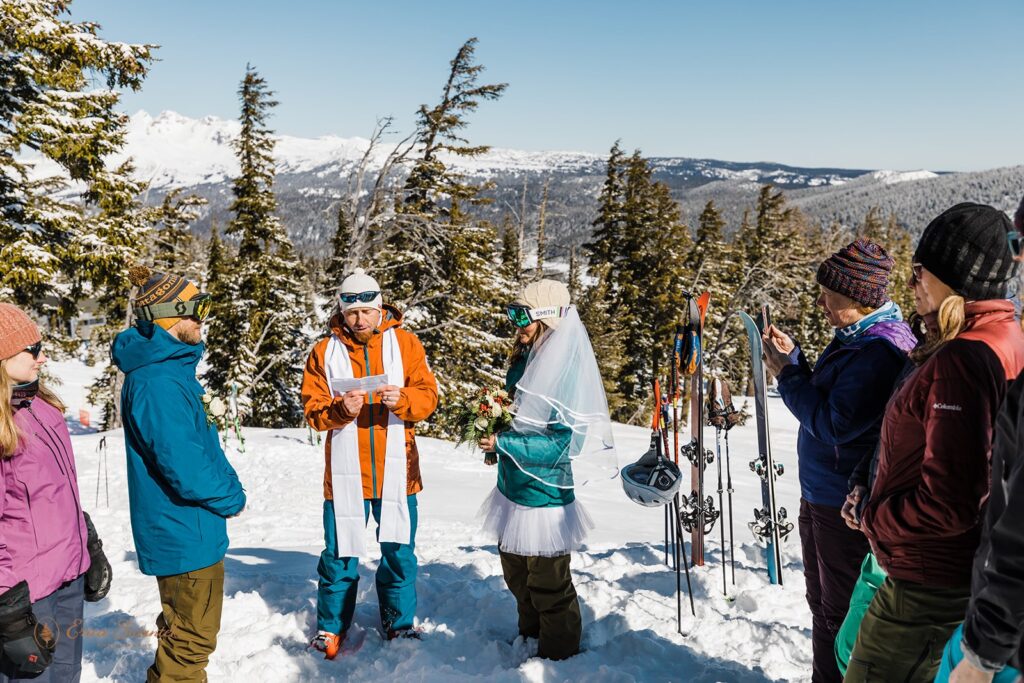 Guests watch a vow ceremony on the slopes of Mt. Bachelor during a ski wedding. 
