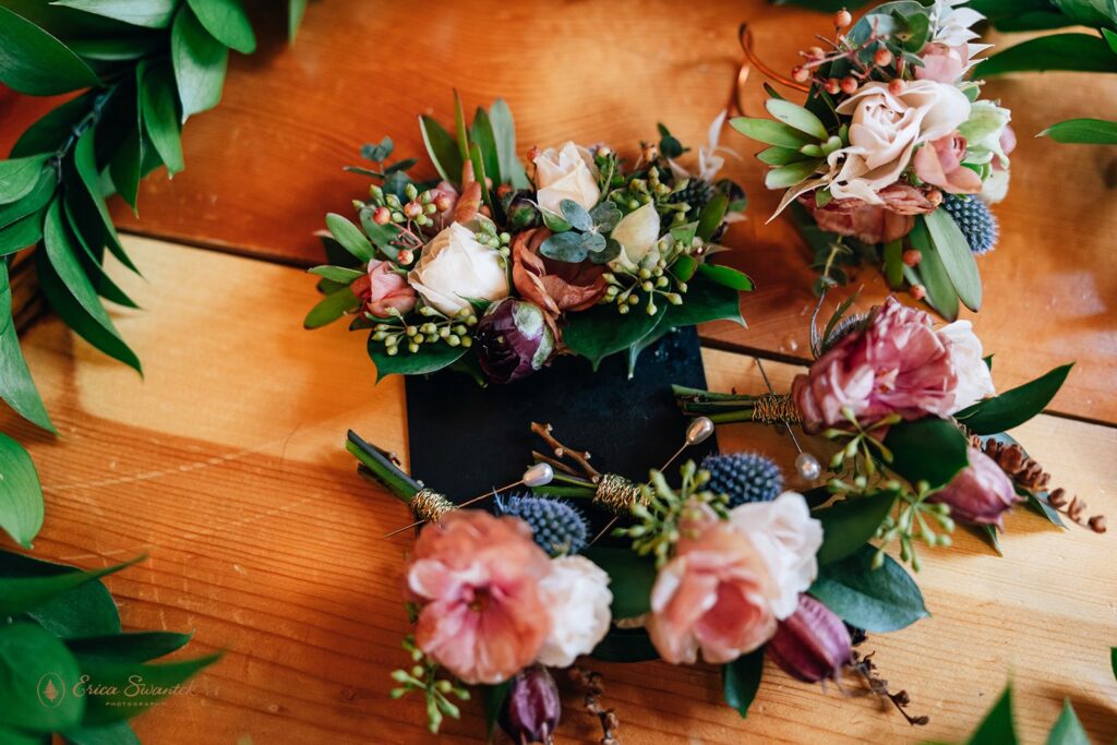 A maile lei wrapped around dusty rose wedding florals.