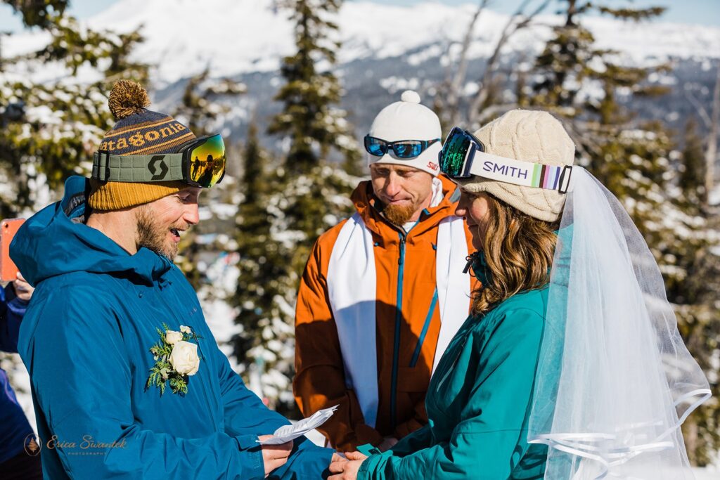 A groom dressed in ski attire recites vows to his bride during their Mt. Bachelor elopment. 