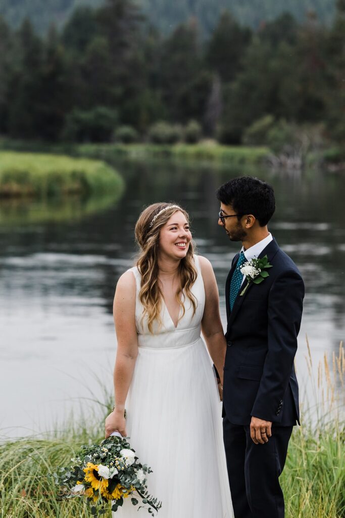 A couple dressed in formal wedding attire admire one another at Sunriver during their intimate wedding portraits in Oregon. 
