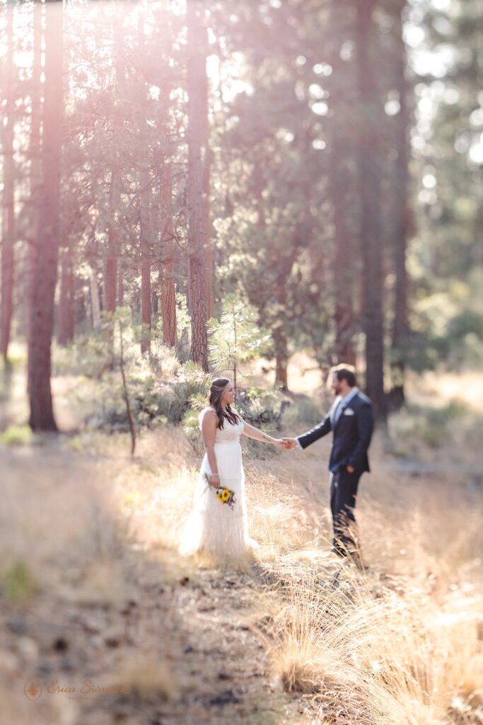 A bride holding a sunflower bouquet holds her groom's hand during their Deschutes River Trail elopement. 