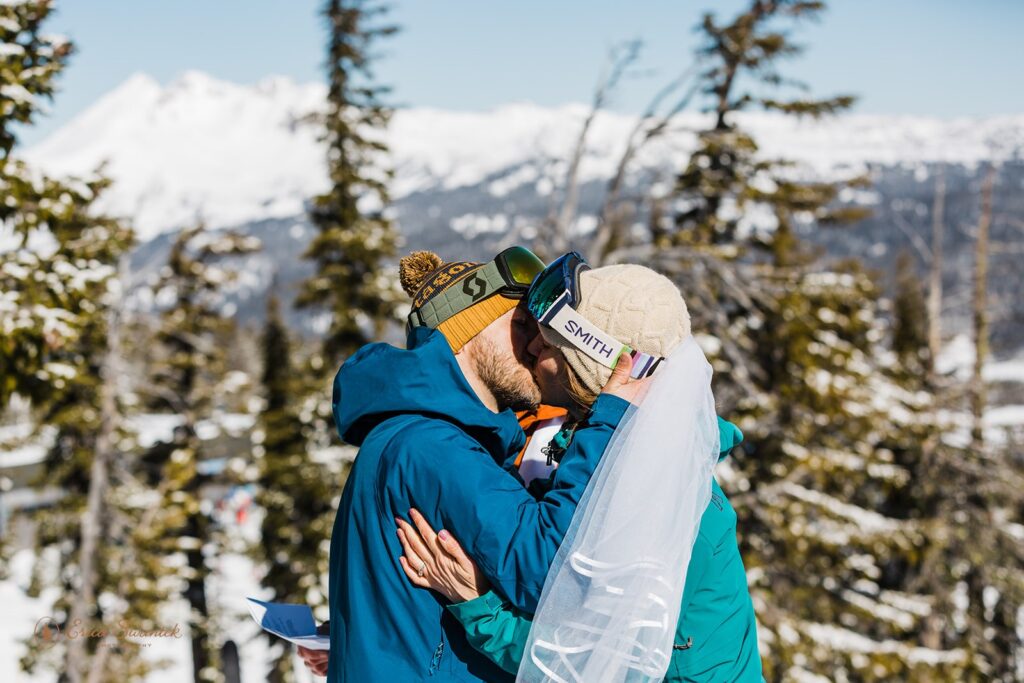 A Mt. Bachelor elopement couple kiss during their Winter ski ceremony in Oregon. 
