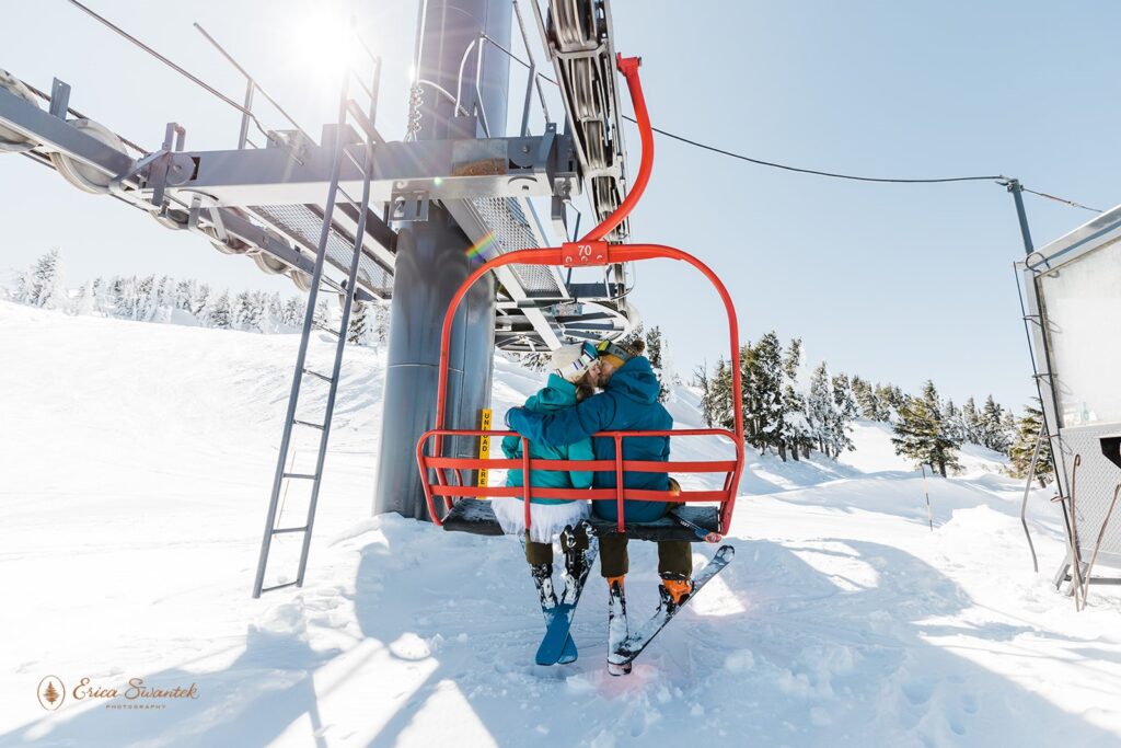 A ski elopement couple kiss on the Mt. Bachelor Summit Lift during Winter. 