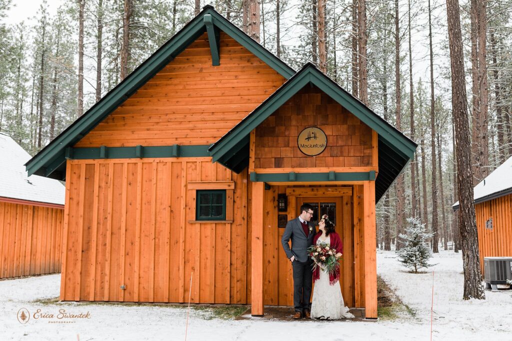 A bride and groom admire one another in the doorway of a cabin at FivePine Lodge near Bend, Oregon. 