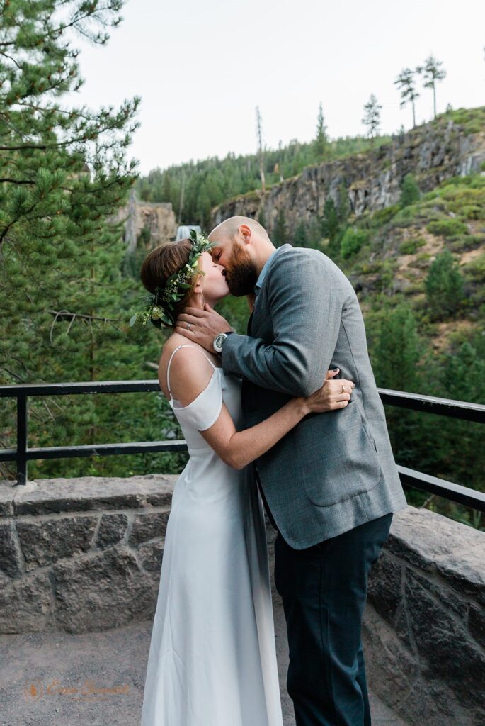 A newlywed couple shares a kiss at Tumalo Falls near Bend, Oregon 