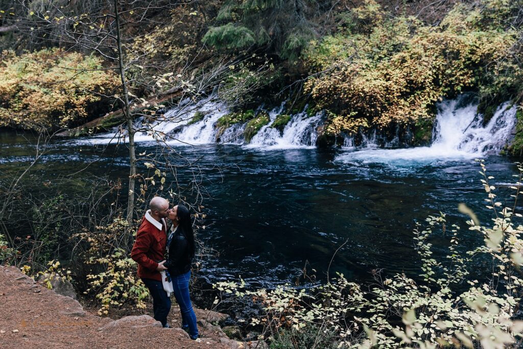 A couple kisses during a couples session at Metolius River near Bend, Oregon. 
