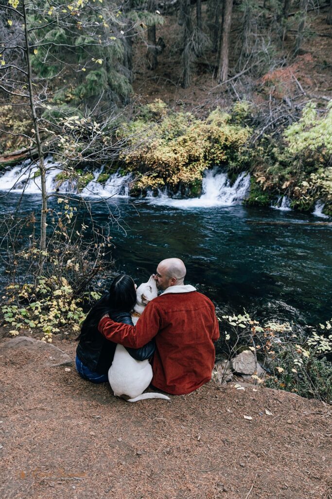 A couple with their dog during a Fall engagement session at Metolius River near Bend, Oregon. 
