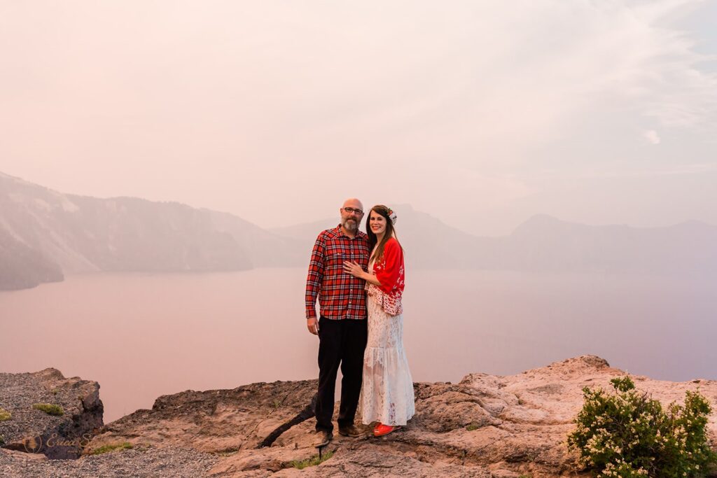 An elopement couple poses for a portrait on an overlook at Crater Lake.