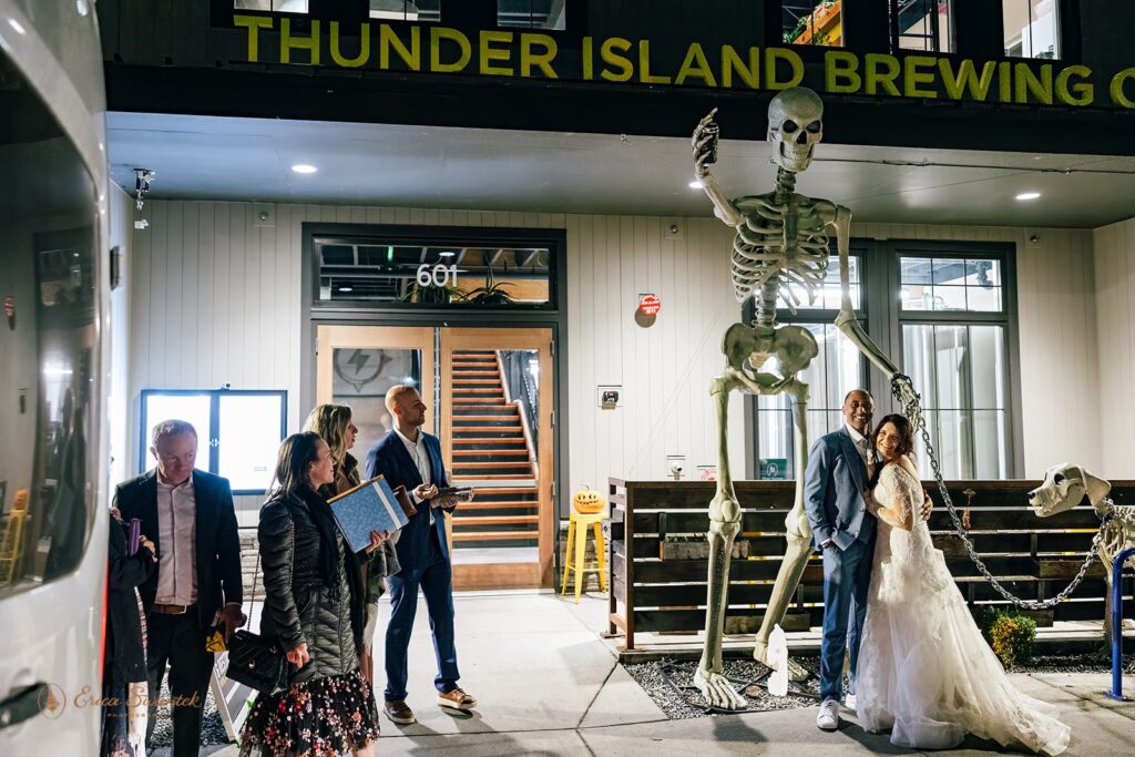 bride and groom posing in front of thunder island brewing 