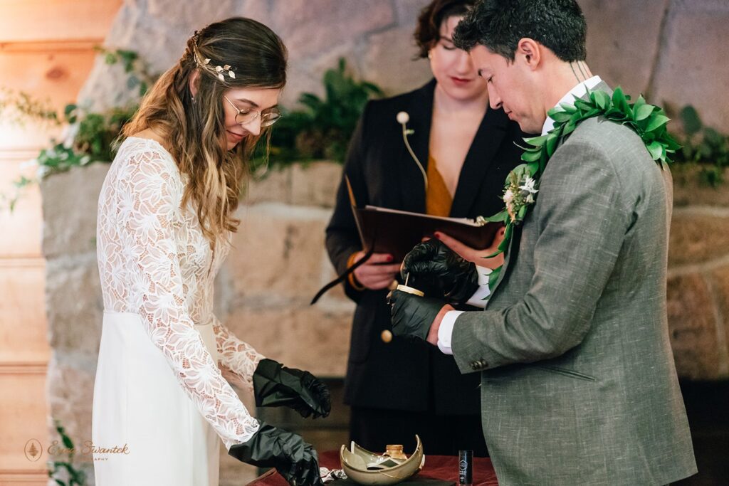 bride and groom performing a kitsungi unity ceremony during their cabin wedding day