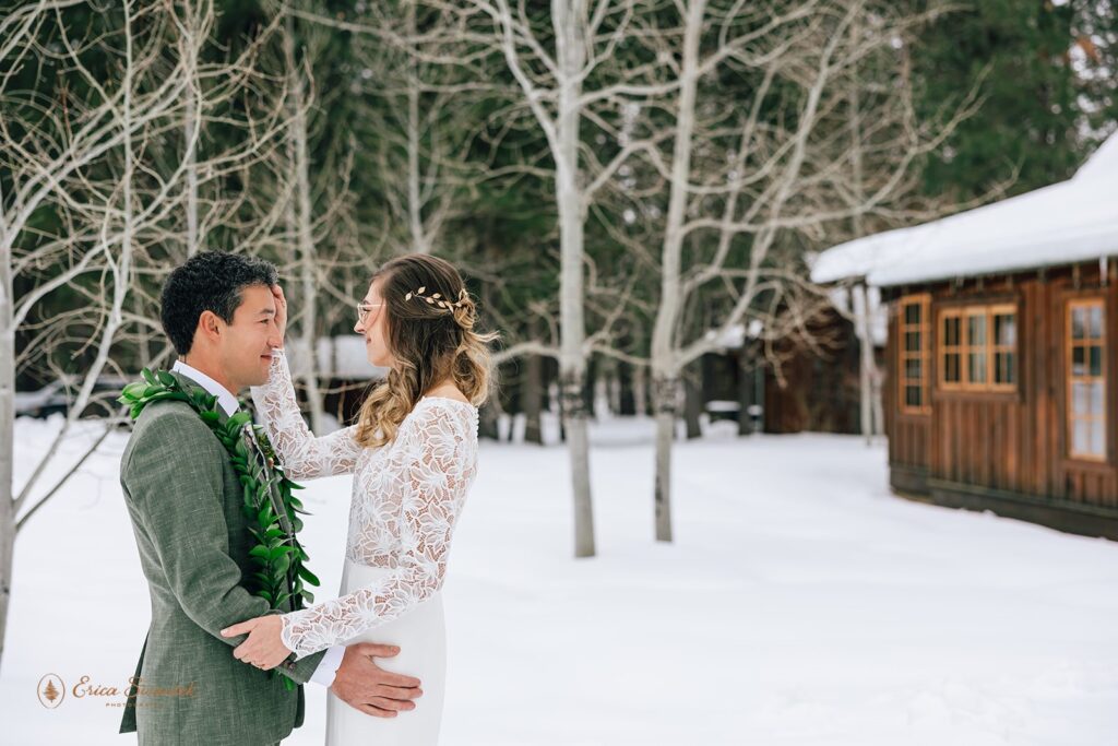 groom admiring his bride during the first look outside surrounded by snow