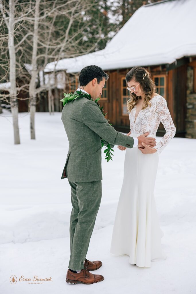 groom admiring his bride during the first look outside surrounded by snow