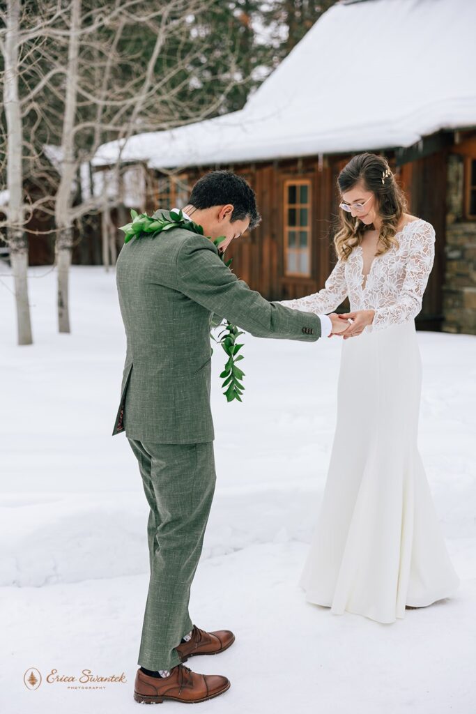 groom admiring his bride during the first look outside surrounded by snow