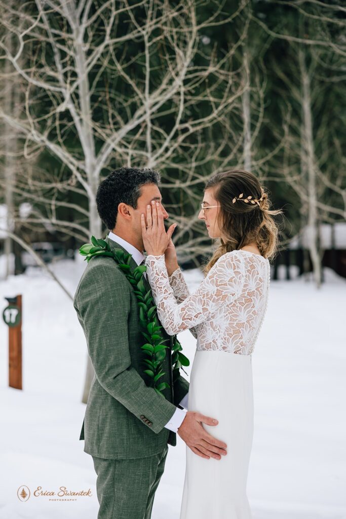 groom admiring his bride during the first look outside surrounded by snow