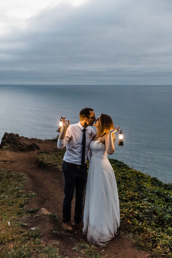 bride and groom hugging while holding lanterns during their nighttime elopement session