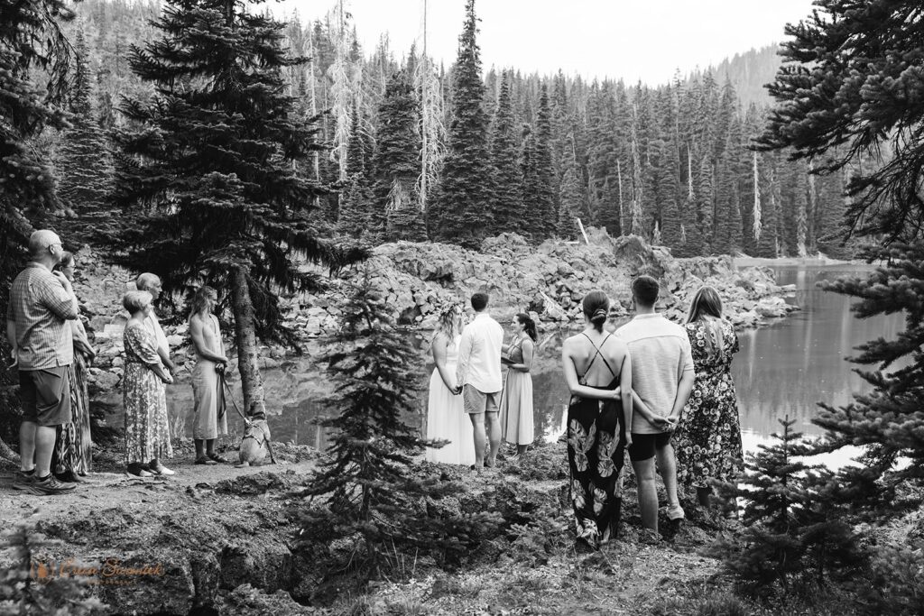 black and white elopement ceremony in the forest by a little lake