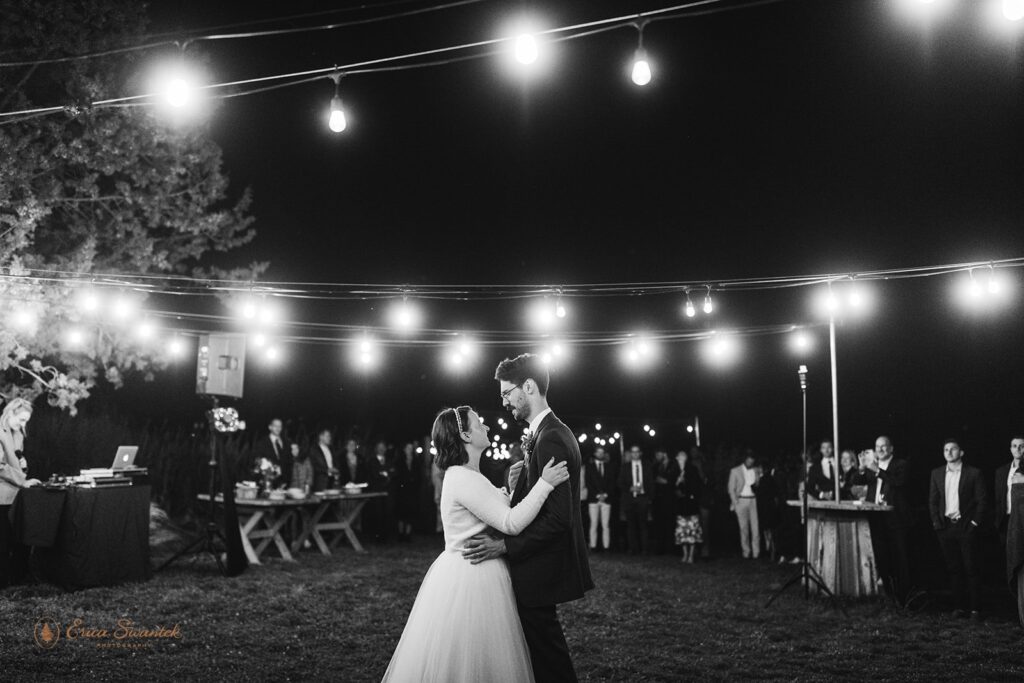 black and white photo of bride and groom's first dance surrounded by twinkly lights